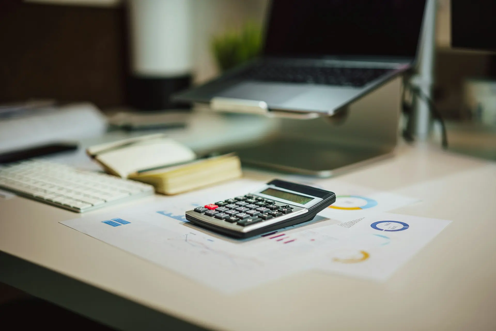 a calculator sitting on top of a table next to a laptop